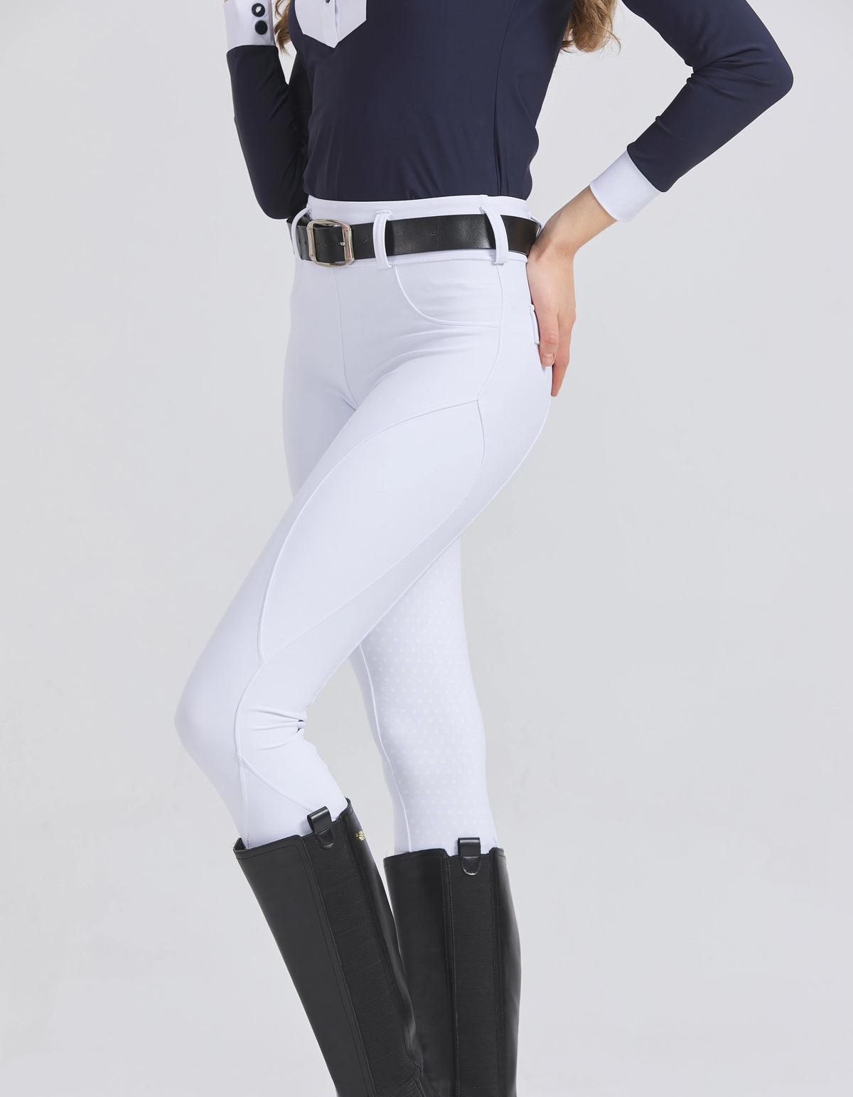 Woman wearing white horse riding breeches with riding boots
